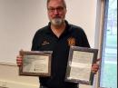 Ed Menasian, N8LPQ, with his ARRL Technical Service Award plaque and motion certificate. [Photo courtesy of Robert Hall, KV8P]